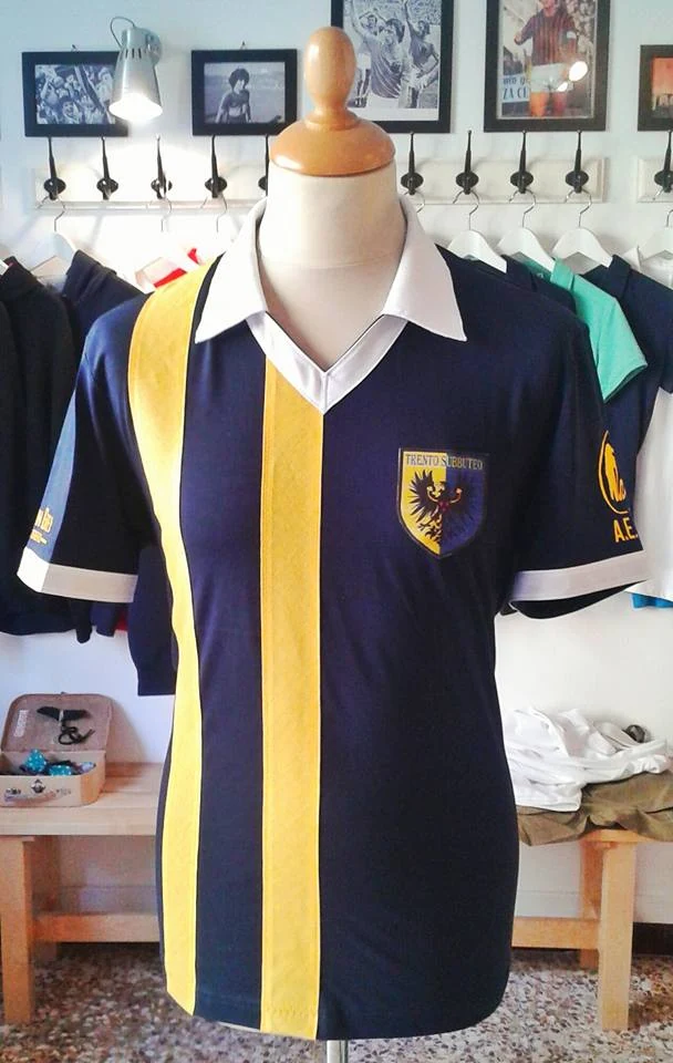 Maglia blu e gialla Trento Subbuteo con colletto bianco, fotografata nella bottega